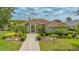 Charming single-story home featuring a tile roof, an arched doorway with columns, and beautifully landscaped front yard at 7305 Chatsworth Ct, University Park, FL 34201