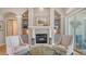 Relaxing living room features a cozy fireplace, custom built-ins, and natural light with access to the pool area at 7305 Chatsworth Ct, University Park, FL 34201