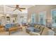 Open-concept living room with coffered ceilings, comfortable seating, and views into the kitchen and dining area at 7305 Chatsworth Ct, University Park, FL 34201