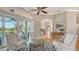 Bright living room with a ceiling fan, light-colored walls, hardwood floors and view to the pool and patio at 7305 Chatsworth Ct, University Park, FL 34201