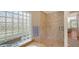 Bathroom featuring tiled shower, glass block window, and neutral color palette at 7305 Chatsworth Ct, University Park, FL 34201