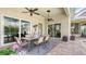 Covered patio with a dining set, ceiling fans, and view of the backyard at 7305 Chatsworth Ct, University Park, FL 34201