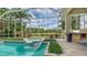 Screened pool and spa with views of the lake, outdoor kitchen with natural light from the sky at 7305 Chatsworth Ct, University Park, FL 34201