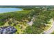 Expansive aerial view of a neighborhood near a lake, highlighting tree coverage and community layout at 7407 91St E St, Palmetto, FL 34221