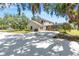 Home's rear view showcasing a spacious yard, garage, and screened-in lanai at 7407 91St E St, Palmetto, FL 34221