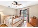 Inviting bedroom with a ceiling fan, wood floors, and sliding doors to the backyard pool at 7407 91St E St, Palmetto, FL 34221