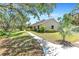 Charming single-story home featuring a well-manicured lawn, mature trees, and a welcoming walkway at 7407 91St E St, Palmetto, FL 34221