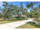 Charming single-story home on expansive lawn featuring mature trees and a long concrete driveway at 7407 91St E St, Palmetto, FL 34221