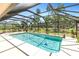 Sparkling screened-in pool surrounded by a spacious patio and lush greenery for ultimate relaxation and privacy at 7407 91St E St, Palmetto, FL 34221