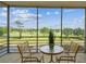 Balcony featuring a cozy seating area with serene views of the golf course and waterway at 7461 W Country Club Dr N # 408, Sarasota, FL 34243