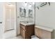 Bathroom featuring a single sink vanity, mirrored wall, glass shelf, and toilet at 7461 W Country Club Dr N # 408, Sarasota, FL 34243