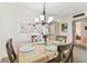 Light dining room featuring a wooden dining set, floral art, and a chandelier at 7461 W Country Club Dr N # 408, Sarasota, FL 34243