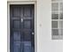 Unit 408's front door is a stylish black door with a traditional knocker and adjacent window at 7461 W Country Club Dr N # 408, Sarasota, FL 34243
