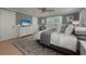 Comfortable bedroom with natural light has a ceiling fan, dresser with TV, and a neutral color palette at 750 Tarawitt Dr, Longboat Key, FL 34228