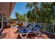 Spacious wood deck with comfortable lounge chairs, wicker furniture, and tropical views at 750 Tarawitt Dr, Longboat Key, FL 34228