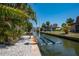 Waterfront home featuring a private boat lift along a scenic canal at 750 Tarawitt Dr, Longboat Key, FL 34228