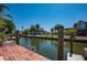Waterfront property featuring a private dock with clear canal views on a sunny day at 750 Tarawitt Dr, Longboat Key, FL 34228