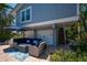 Outdoor patio with blue furniture, a fire pit, and access to the garage and stairs at 750 Tarawitt Dr, Longboat Key, FL 34228