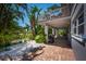Inviting backyard with covered patio, lush landscaping, and outdoor grill at 750 Tarawitt Dr, Longboat Key, FL 34228