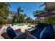 Inviting backyard pool area with comfortable seating, a fire pit, and lush landscaping, perfect for gatherings at 750 Tarawitt Dr, Longboat Key, FL 34228