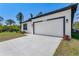 A modern garage adds curb appeal with a clean driveway, exterior lighting, and updated landscaping at 7852 Tasco Dr, North Port, FL 34291
