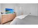 Modern bedroom with dresser, TV, and view into the on-suite bathroom at 7859 Yale Harbor Dr, Wesley Chapel, FL 33545