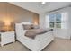 Cozy bedroom with a white bed frame, neutral decor, and soft natural light at 7859 Yale Harbor Dr, Wesley Chapel, FL 33545