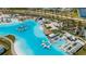 An aerial view showcasing a large lagoon-style community pool with a water park and poolside lounging at 7859 Yale Harbor Dr, Wesley Chapel, FL 33545