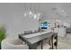 Elegant dining area featuring pendant lighting, modern furniture, and views of the living area and kitchen at 7859 Yale Harbor Dr, Wesley Chapel, FL 33545