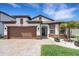 Charming single Gathering home with a two-car garage, beautiful brick paver driveway and manicured lawn at 7859 Yale Harbor Dr, Wesley Chapel, FL 33545