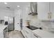 Modern kitchen boasts stainless steel appliances, white cabinets, and elegant marble backsplash at 7859 Yale Harbor Dr, Wesley Chapel, FL 33545