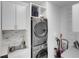 Functional laundry room with stacked washer and dryer, a sink, and ample storage at 7859 Yale Harbor Dr, Wesley Chapel, FL 33545