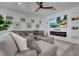 Spacious living room with a large sectional sofa, cozy decor and sleek modern fireplace at 7859 Yale Harbor Dr, Wesley Chapel, FL 33545