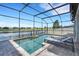 Refreshing pool and tanning deck with expansive lake view and screened enclosure at 7859 Yale Harbor Dr, Wesley Chapel, FL 33545