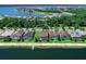 Aerial view of the home on a lake with a screened-in pool and well-maintained yard at 7864 Grande Shores Dr, Sarasota, FL 34240