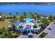 Aerial view of a community clubhouse, pool, and manicured lawns near a lake at 7864 Grande Shores Dr, Sarasota, FL 34240