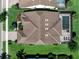 Aerial view of the home with a tile roof, screened-in pool, and lush landscaping at 7864 Grande Shores Dr, Sarasota, FL 34240