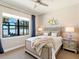Cozy bedroom with scenic lake views from a large window, enhancing the room's tranquil setting at 7864 Grande Shores Dr, Sarasota, FL 34240