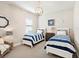 Nautical themed bedroom with twin beds, coastal decor, and a stylish light fixture at 7864 Grande Shores Dr, Sarasota, FL 34240