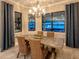 Elegant dining room featuring a wood table, decorative chandelier, and scenic water views at 7864 Grande Shores Dr, Sarasota, FL 34240