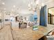 Open concept dining room showcasing a rustic table, modern chandelier, and inviting living spaces at 7864 Grande Shores Dr, Sarasota, FL 34240