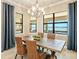 Elegant dining room with wood table, woven chairs, chandelier, and scenic water view at 7864 Grande Shores Dr, Sarasota, FL 34240