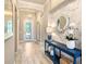 Elegant entryway with decorative glass door, mirror, console table, and accent wall creates a welcoming first impression at 7864 Grande Shores Dr, Sarasota, FL 34240