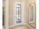 Bright entryway featuring a decorative glass front door and stylish mirror, enhanced by natural light and neutral tones at 7864 Grande Shores Dr, Sarasota, FL 34240