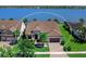 Well-maintained home with a manicured lawn, mature trees, and a paver driveway at 7864 Grande Shores Dr, Sarasota, FL 34240