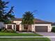 Elegant home featuring a tile roof, well-manicured lawn, tropical landscaping, and a two-car garage at 7864 Grande Shores Dr, Sarasota, FL 34240