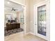 Inviting foyer with decorative glass door, opening into a spacious office with a ceiling fan at 7864 Grande Shores Dr, Sarasota, FL 34240
