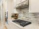 Close-up view of a modern kitchen with granite countertops, stainless steel appliances, and stylish backsplash at 7864 Grande Shores Dr, Sarasota, FL 34240