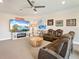 Entertainment area features a comfy brown sofa, entertainment center and fan- making it ideal for relaxation and gatherings at 7864 Grande Shores Dr, Sarasota, FL 34240