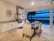 Covered outdoor kitchen and dining area overlooking the lake, perfect for alfresco meals and entertaining guests at 7864 Grande Shores Dr, Sarasota, FL 34240